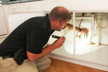 HouseMaster technician inspecting under sink