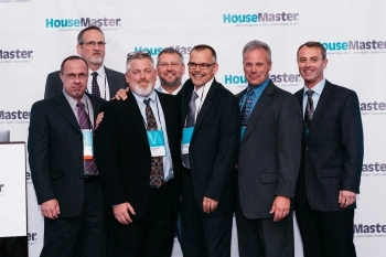 Joe Lattarulo and six team members with Housemaster wall backdrop