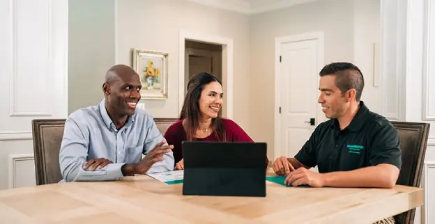 HouseMaster Serving Cleveland inspector reviewing a home buyer inspection report with a couple on a laptop.