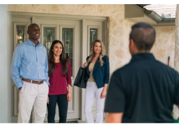 HouseMaster Inspector greeting three people at the front door.