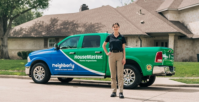 Woman standing in front of branded HouseMaster van