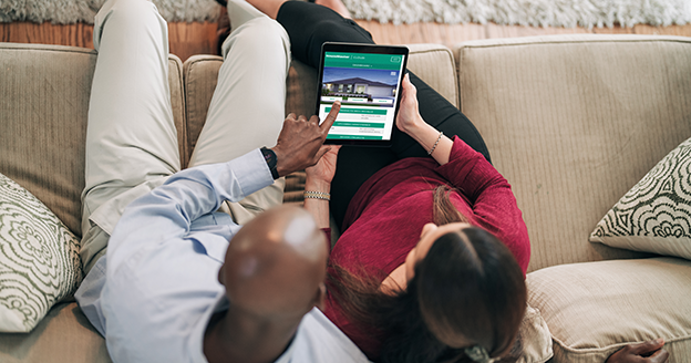 Couple on couch reviewing HMS website.