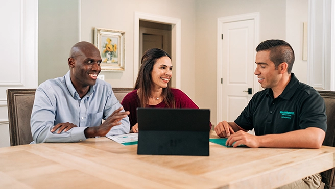 HouseMaster representative showing couple laptop.