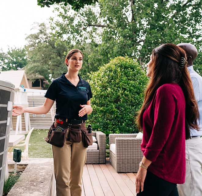 HouseMaster standing in back yard with two people.