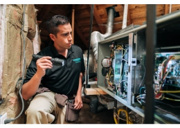 HouseMaster inspector reviewing air conditioning components inside of an attic.