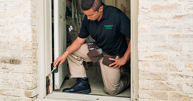 Inspector checking rotten doorframe.