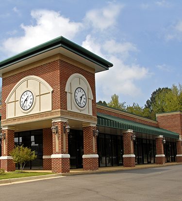 Multiple attached commercial properties with clock.