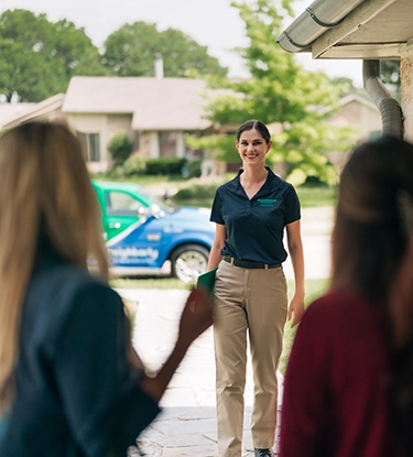 HouseMaster female inspector greeting three people at home.