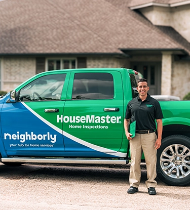 HouseMaster male inspector standing in front of branded truck.