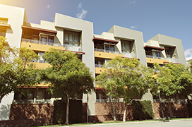 Condominium complex with trees in front.