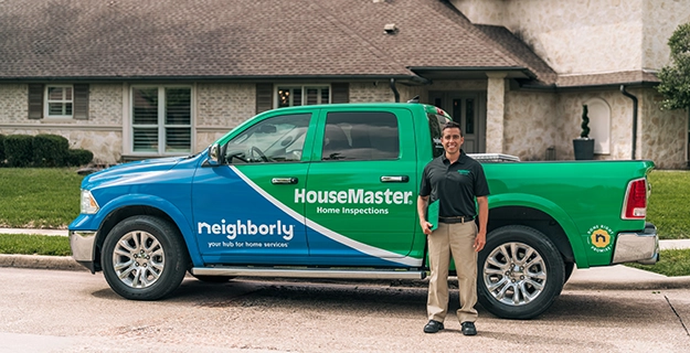 HouseMaster Home Inspector standing next to branded pick-up truck.