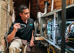 HouseMaster inspector reviewing air conditioning components inside of an attic.