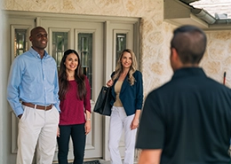 HouseMaster Inspector greeting three people at the front door.