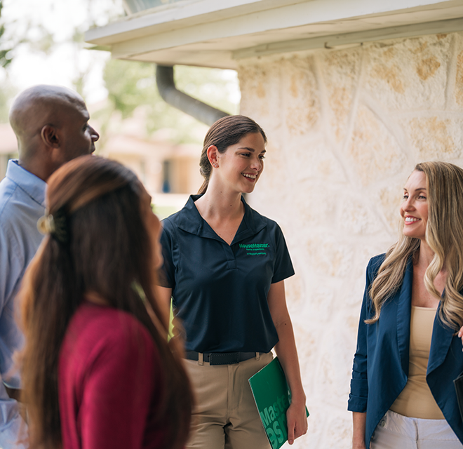 HouseMaster inspector standing with three people on a porch.