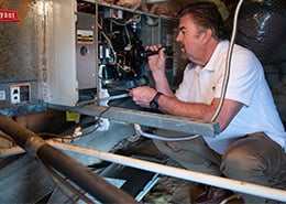 HouseMaster inspector reviewing air conditioning components inside of an attic.