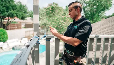 A home inspector takes photos of a second-floor deck with safety concerns.