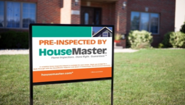 A sign in front of a house saying Pre-inspected by House Master.