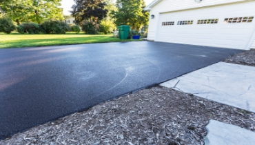 A driveway with a white garage.