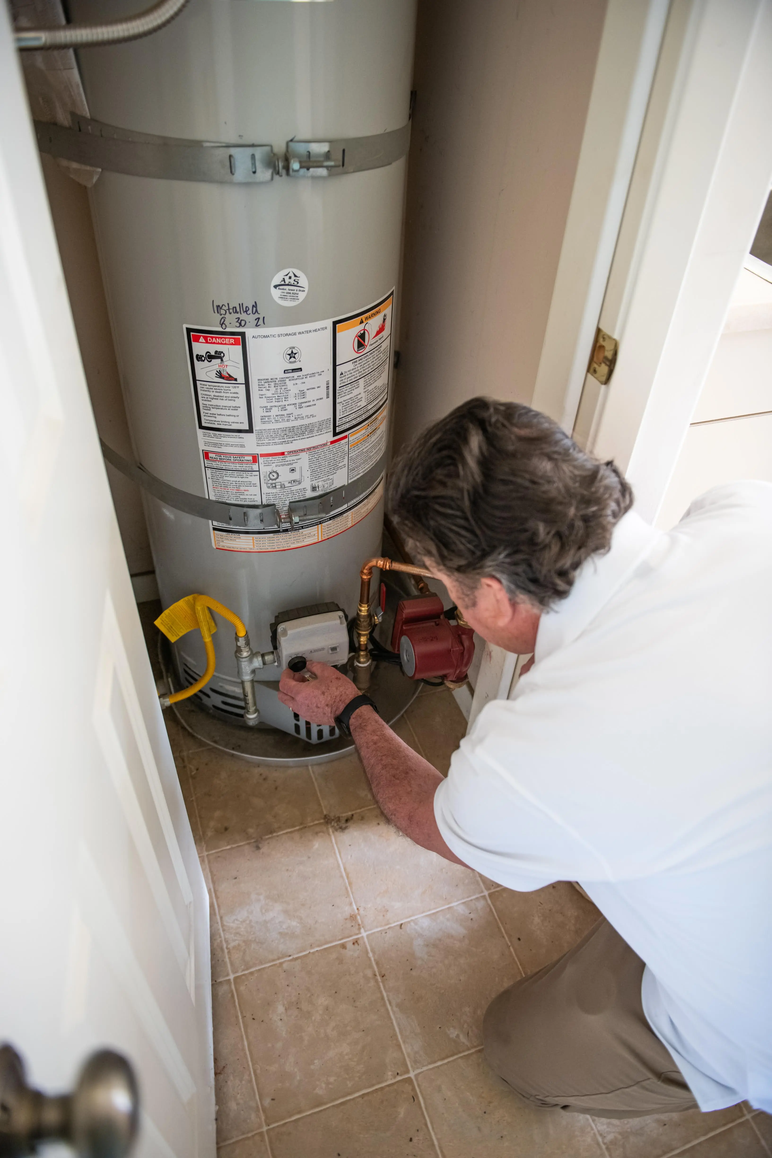 HouseMaster technician inspecting a water heater.