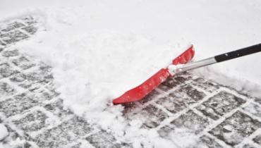 A shovel shoveling snow on the ground.