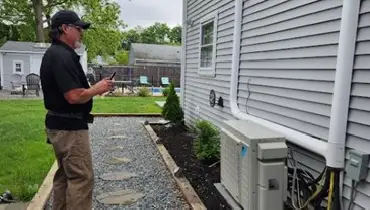 HouseMaster inspector checking side of home.