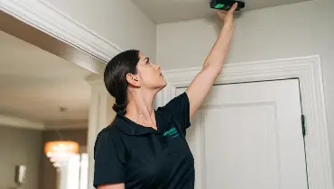 A home inspector uses a moisture meter to assess water in the ceiling.