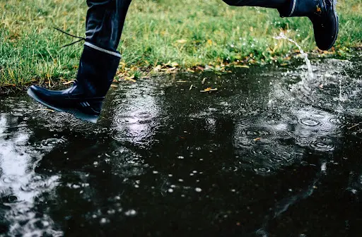 Person jumping on a puddle of rain.